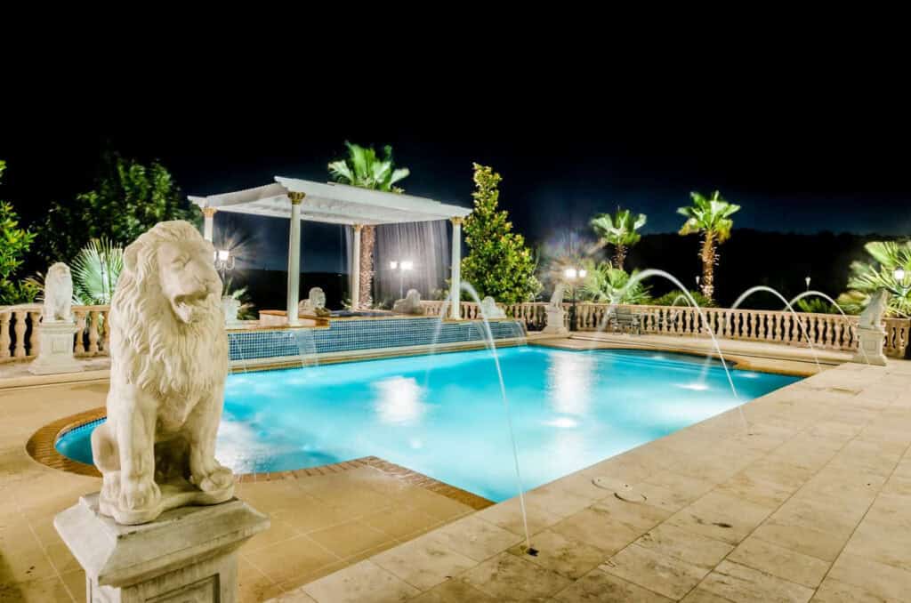 A pool with a statue of a lion next to it.