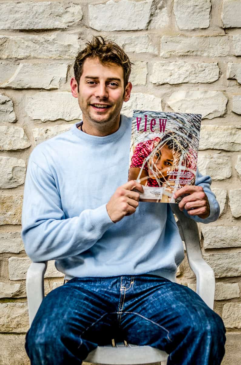 A man sitting on a chair holding a book.