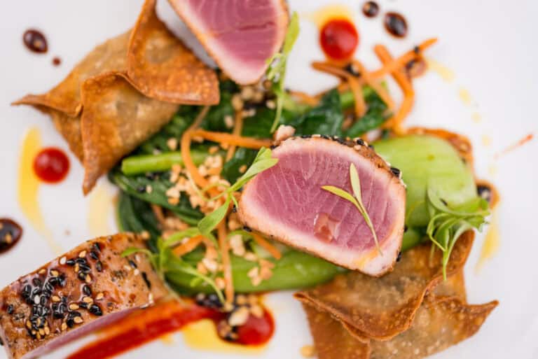 A plate of tuna and vegetables on a white plate.