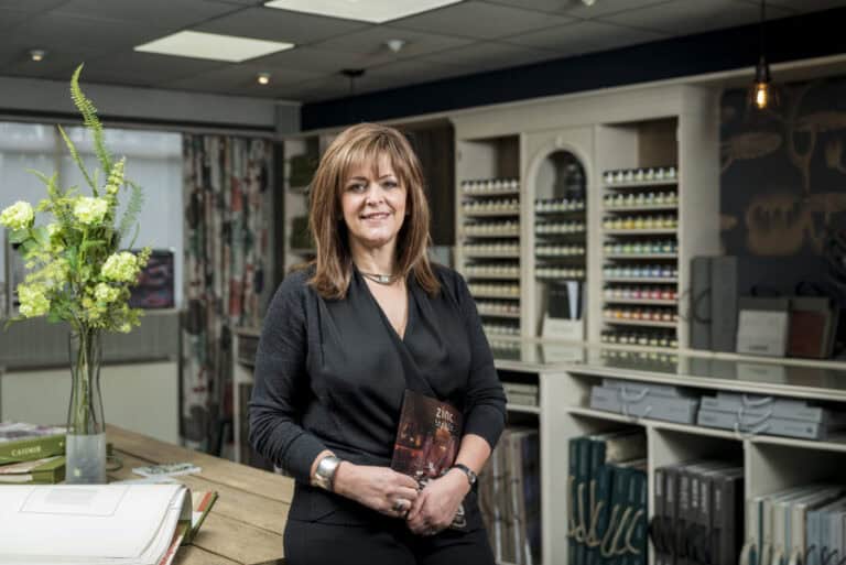 A woman standing in front of a table in a store.