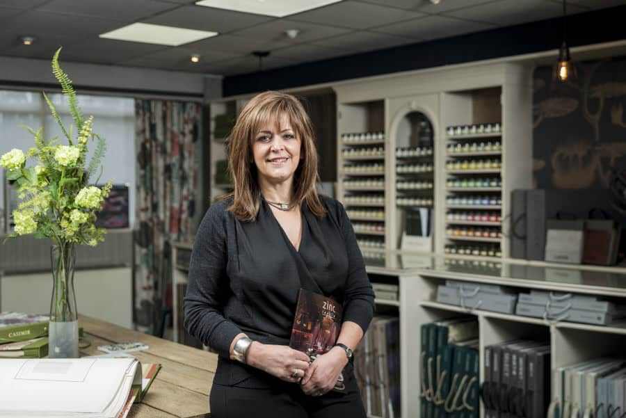 A woman standing in front of a table in a store.