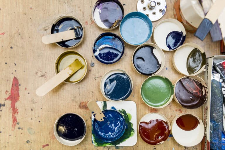 A variety of paints and brushes on a table.