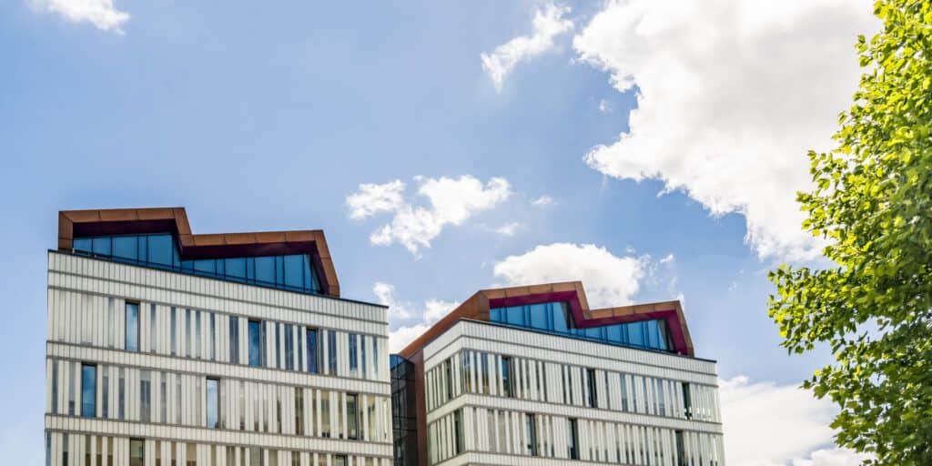 Two buildings with a blue sky behind them.
