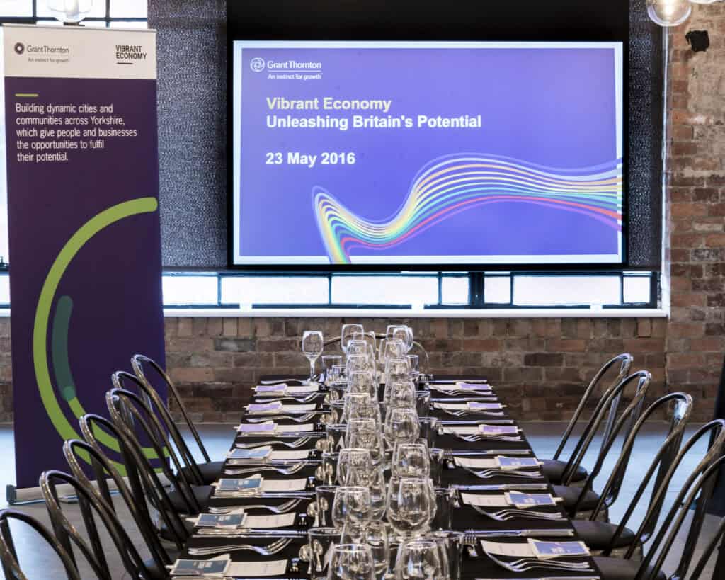 A large room with tables and chairs set up for an event.