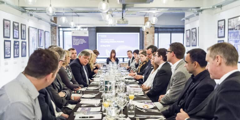 A group of people sitting at a long table.