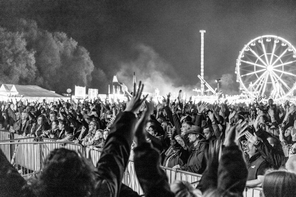 A black and white photo of a crowd at an amusement park.