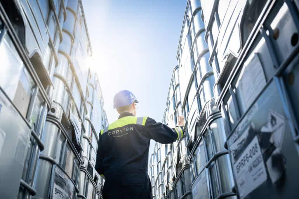 A man in a hard hat is standing in a warehouse.