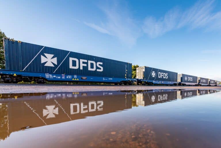 A puddle of water next to a train.