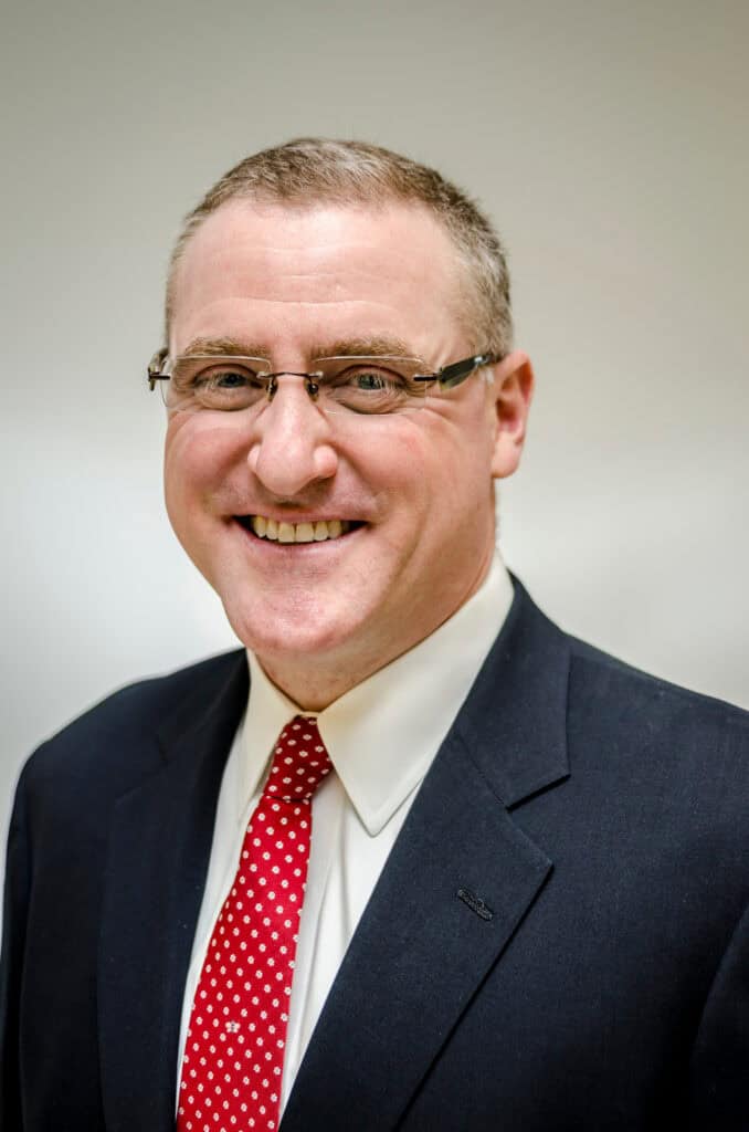 A man in a suit and a red tie.