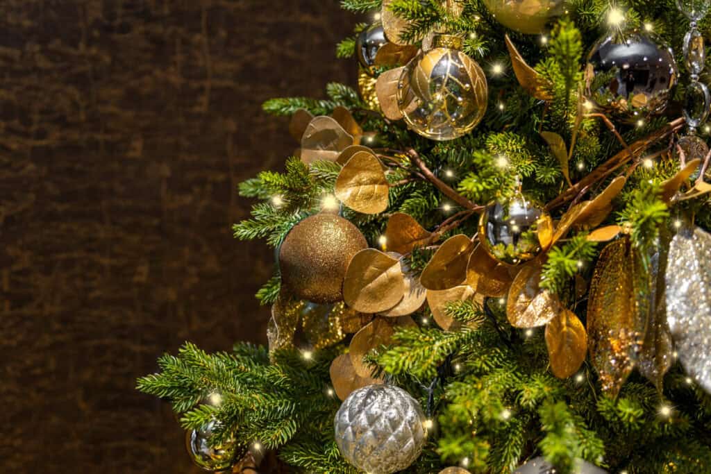 A christmas tree decorated with gold and silver ornaments.