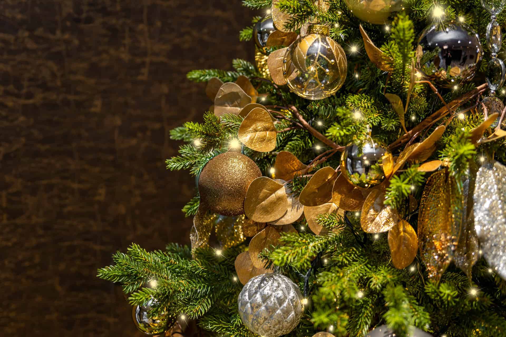 A christmas tree decorated with gold and silver ornaments.
