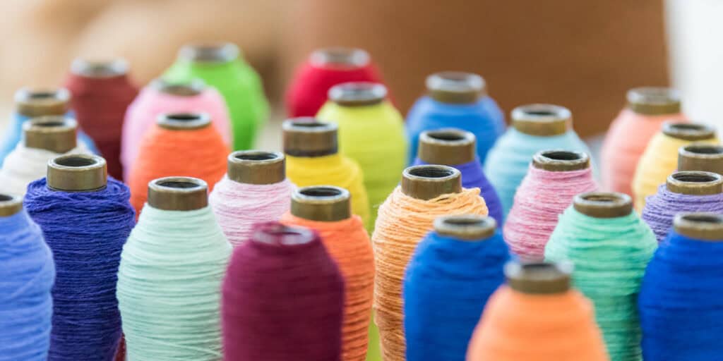 Colorful spools of thread on a table.