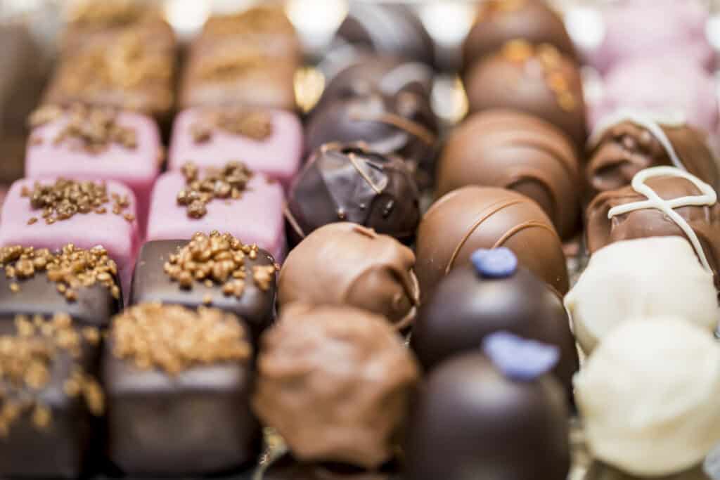 A variety of chocolates are arranged on a silver tray.