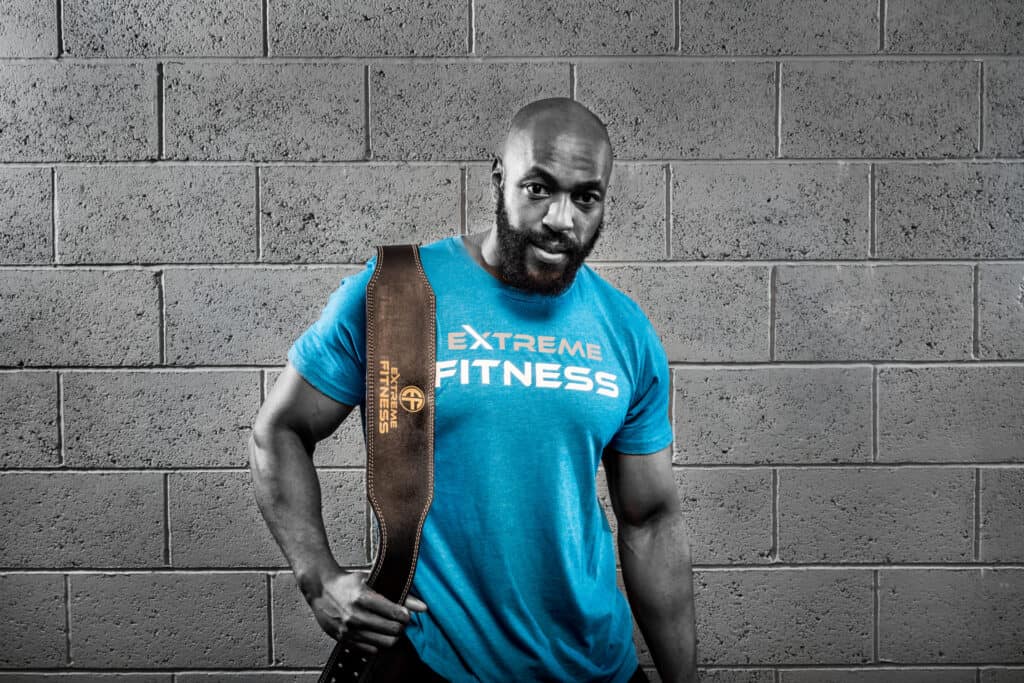 A man in a blue t - shirt holding a blue bag.