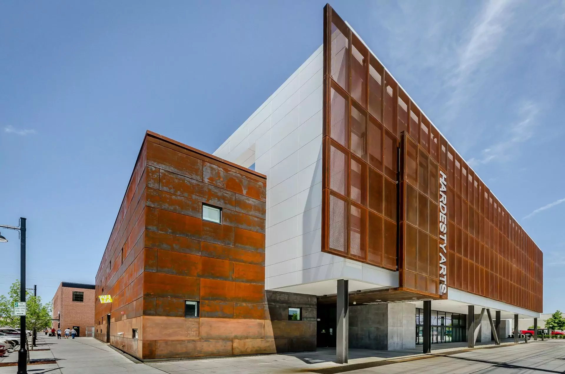 Contemporary arts centre with a weathered steel facade photographed against a clear blue sky